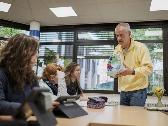 Ein CJD Lehrer zeigt seinen Schülerinnen ein Biologie-Modell
